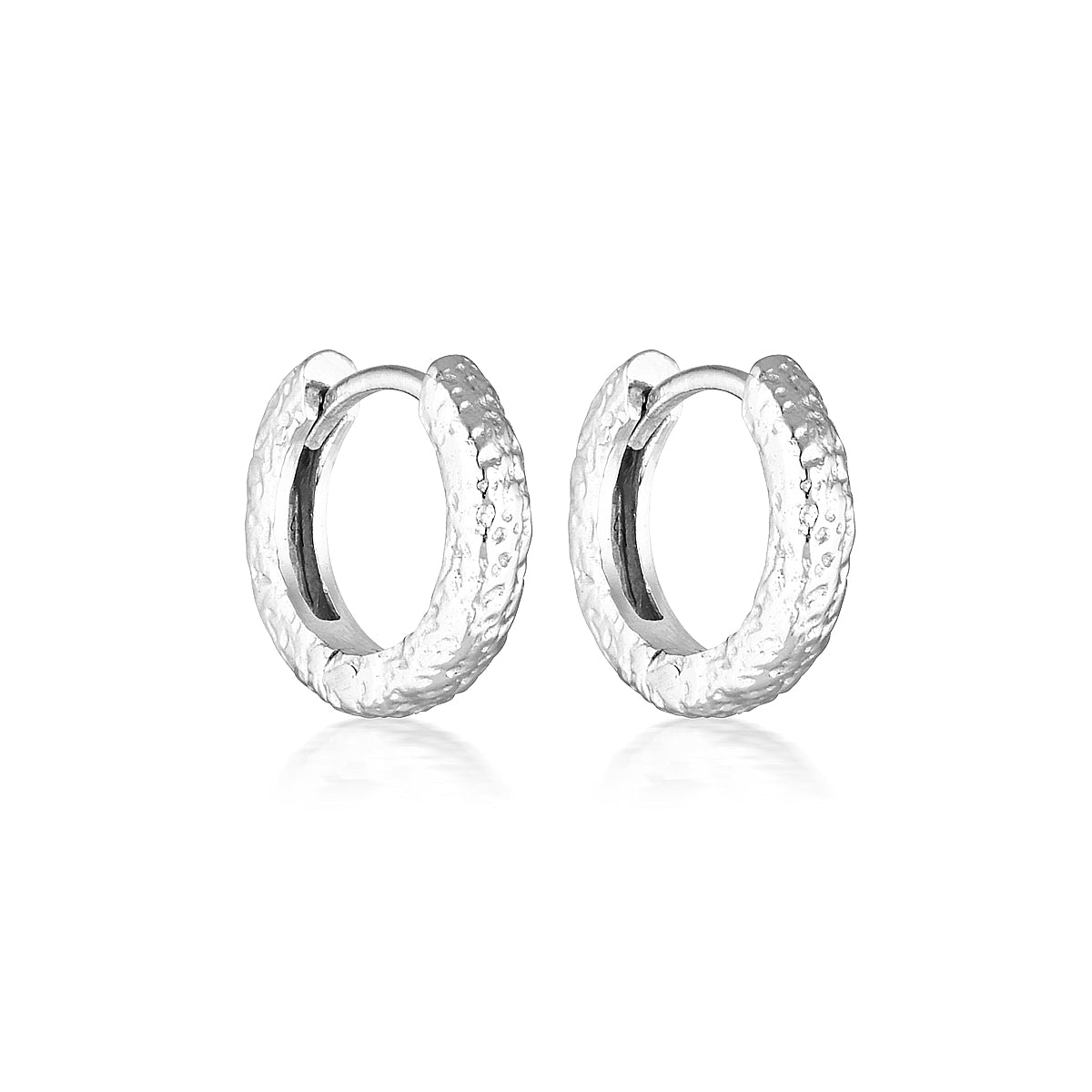 A pair of silver huggie textured earrings with a rhodium plated finish, hypoallergenic and nickel free.
